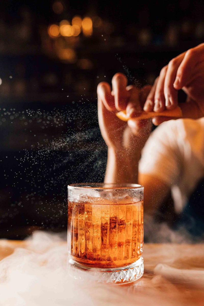 mains préparant un negroni comme idée de cocktails mains préparant un negroni comme idée de cocktails
