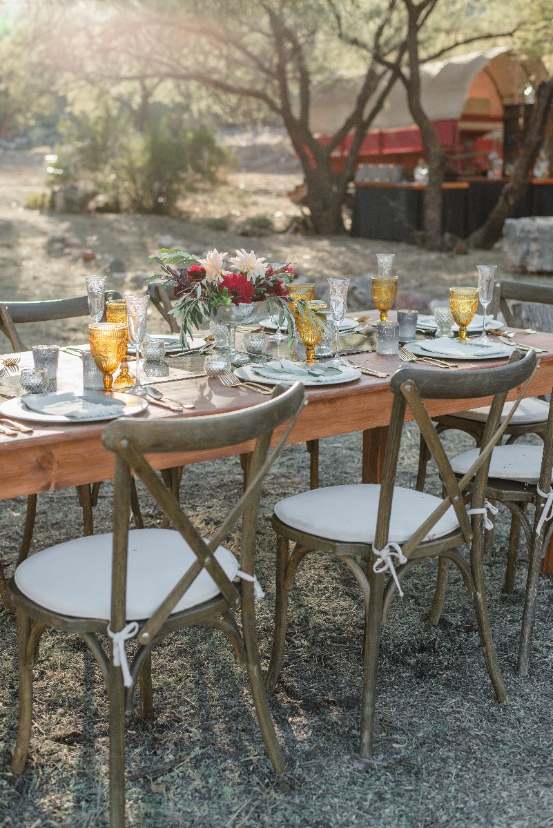 Table décorée avec des fleurs et de la vaisselle dans un jardin Table décorée avec des fleurs et de la vaisselle dans un jardin