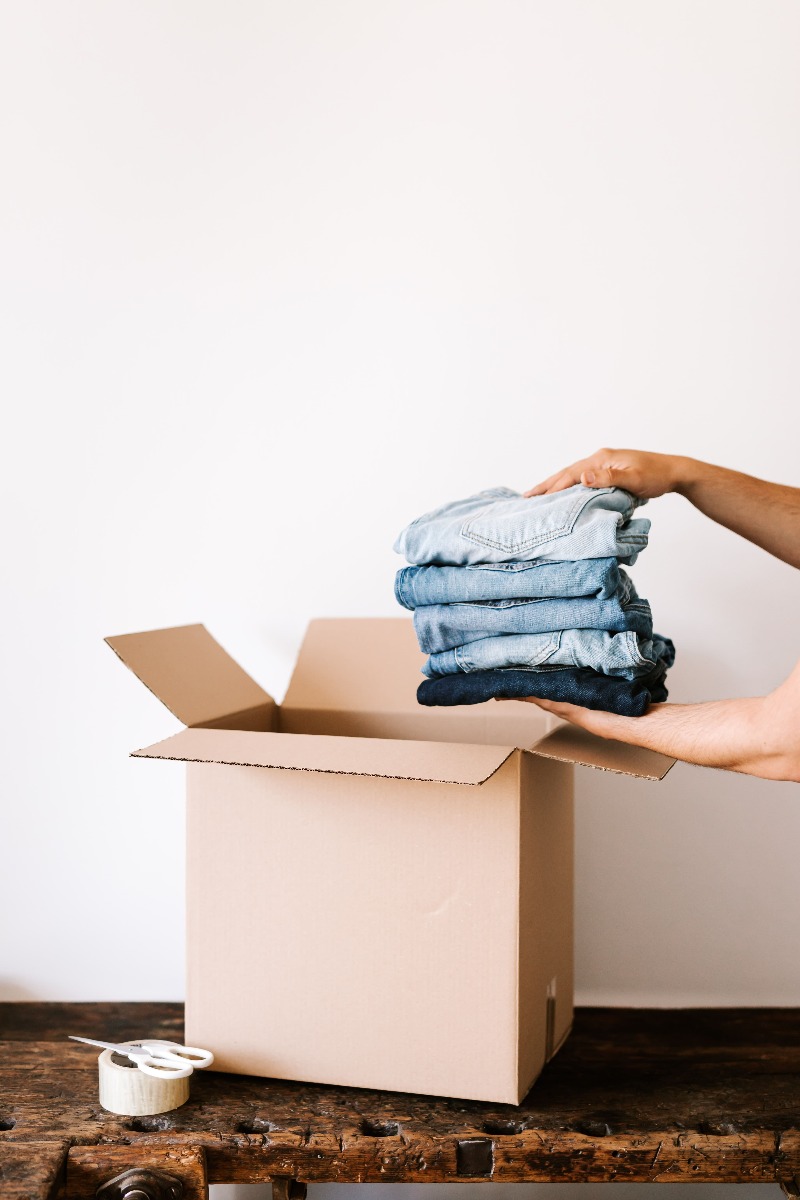jeans pliés placés dans un carton sur une table jeans pliés placés dans un carton sur une table